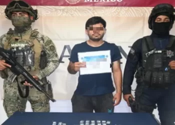Imagen que muestra el momento en que agentes de la Secretaría Municipal de Seguridad Ciudadana y Tránsito detienen a un hombre en la Región 229 de Cancún por posesión de drogas.