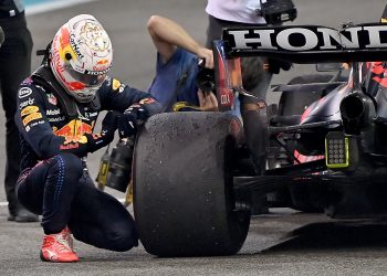 Max Verstappen agachado junto a su Red Bull Honda inspecciona el neumático tras el Gran Premio nocturno de Fórmula 1