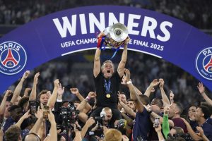 Luis Enrique Martínez es cargado por los futbolistas del PSG mientras sostiene la Copa de la Champions League