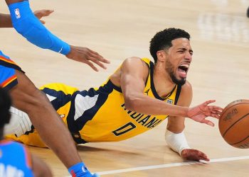 Tyrese Haliburton cae al piso estirando el brazo para alcanzar el balón