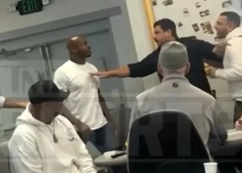 Adrian Peterson encarado con un jugador en la mesa de póker mientras asistentes interceden