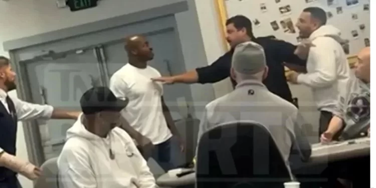 Adrian Peterson encarado con un jugador en la mesa de póker mientras asistentes interceden