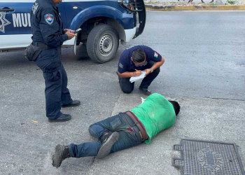 Hombre herido en el suelo atendido por policías en Cancún