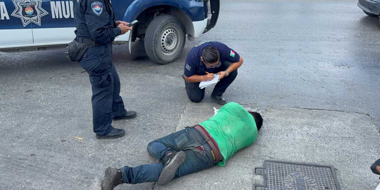 Hombre herido en el suelo atendido por policías en Cancún