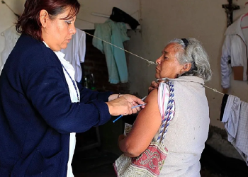 Facilitadora de salud inyectando a una abuelita en su hogar