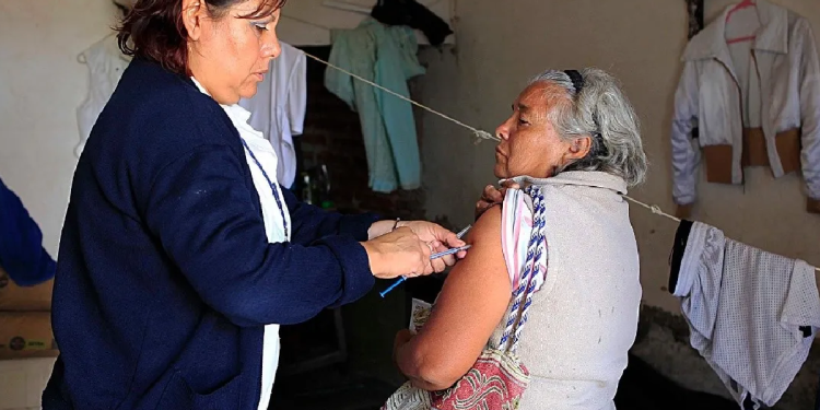 Facilitadora de salud inyectando a una abuelita en su hogar