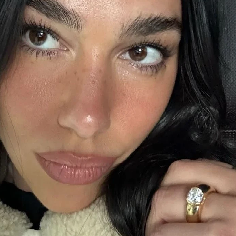 Dua Lipa mostrando el anillo de compromiso diseñado por Callum Turner