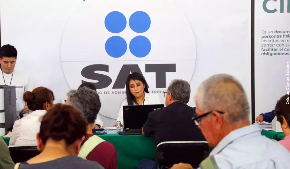 Personas en fila esperando atención en oficinas del SAT