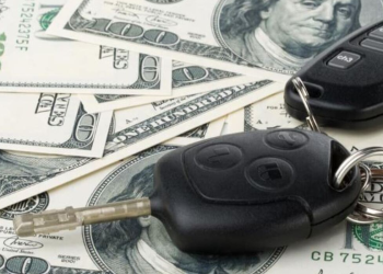 Dinero debajo de llaves de auto simbolizando compra de vehiculo