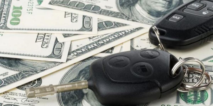 Dinero debajo de llaves de auto simbolizando compra de vehiculo