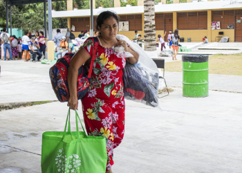 Mujer en Cancún cargando apoyo alimentario de programa social