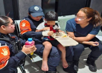 Menor recibiendo alimento con personal del GEAVIG en Puerto Aventuras