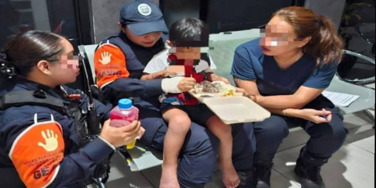 Menor recibiendo alimento con personal del GEAVIG en Puerto Aventuras