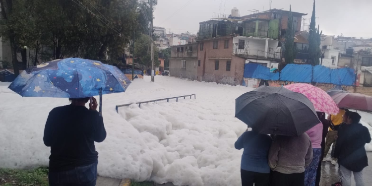 Vecinos observan espuma blanca tras desborde de presa en Naucalpan