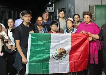 Mexicanos en Irán sosteniendo la bandera de México durante evacuación