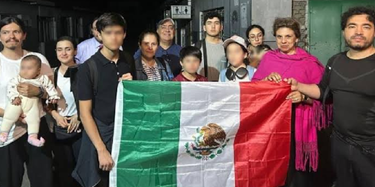 Mexicanos en Irán sosteniendo la bandera de México durante evacuación