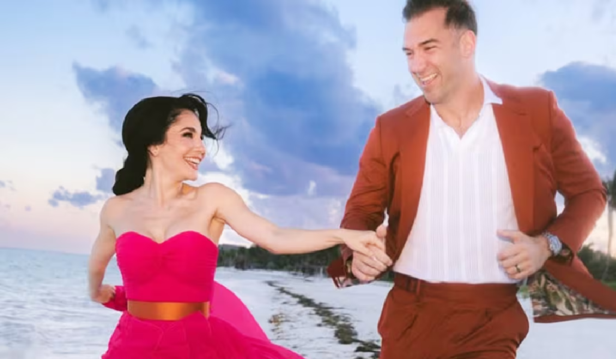 Martha Higareda y su esposo caminando felices en la playa
