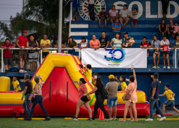 Niños y familias participan junto a un gran castillo inflable en la Carrera Kids por el Agua