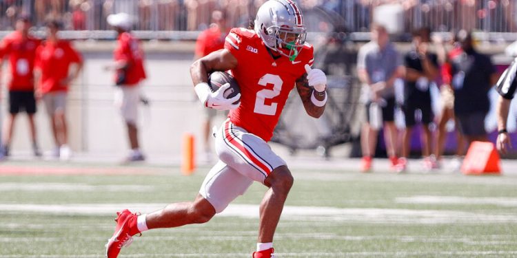 Jugador de Ohio State corriendo con el balón durante un partido colegial