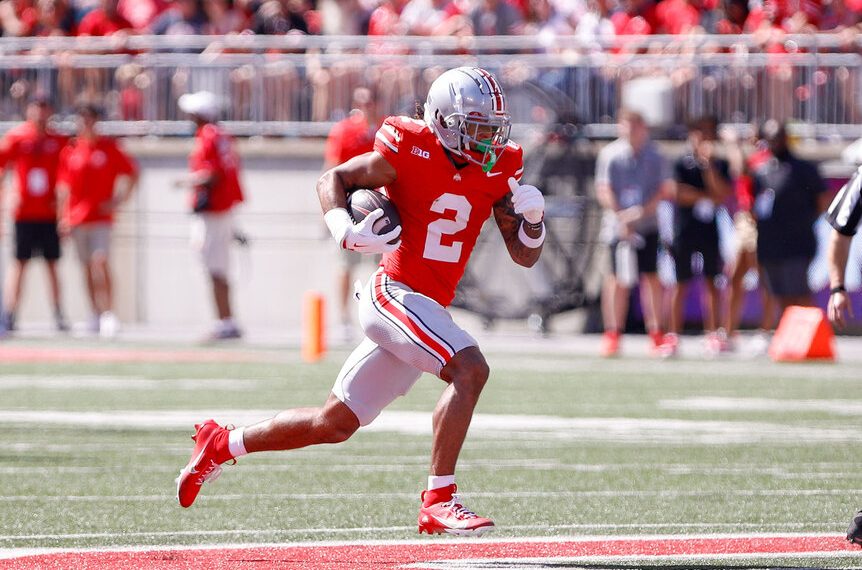 Jugador de Ohio State corriendo con el balón durante un partido colegial