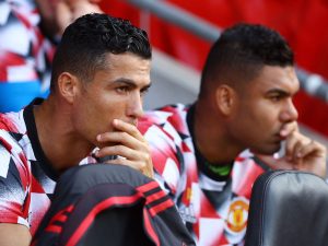 Casemiro y Cristiano Ronaldo sentados en el banquillo observando el partido