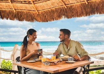 Pareja desayunando frente al mar en Cancún