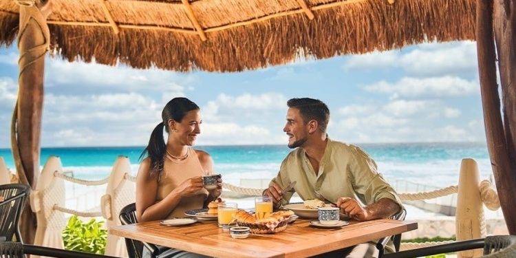 Pareja desayunando frente al mar en Cancún