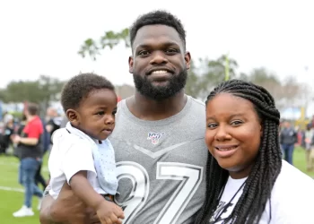 Geno Atkins y su esposa posan con su hijo durante un evento de aficionados de los Bengals