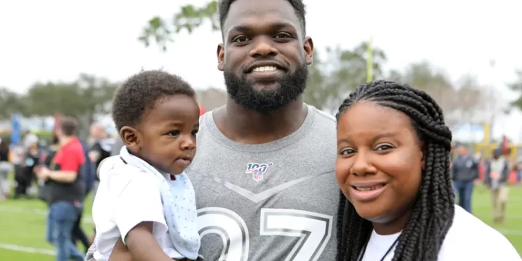Geno Atkins y su esposa posan con su hijo durante un evento de aficionados de los Bengals