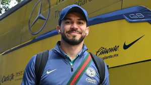 Jugador de Club América sonríe junto al autobús del equipo antes de un partido