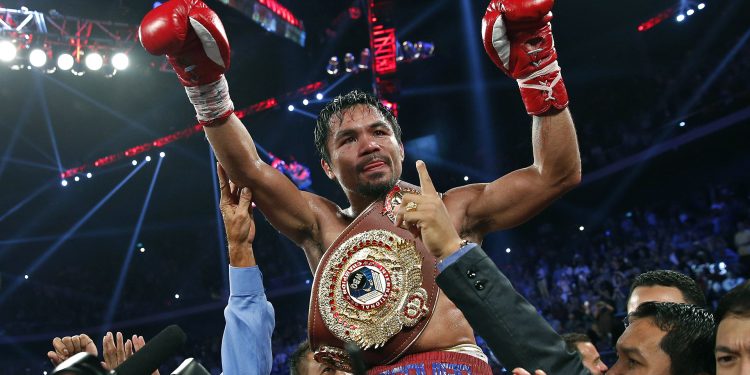 Manny Pacquiao levantando los brazos tras una victoria, con cinturón de campeón welter