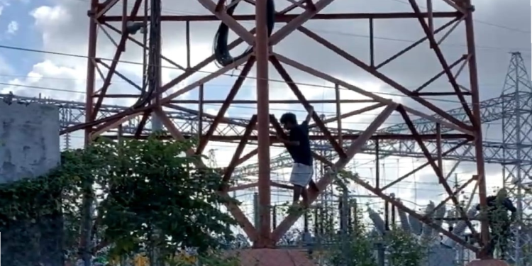 Joven sobre torre de luz en la región 91 de Cancún