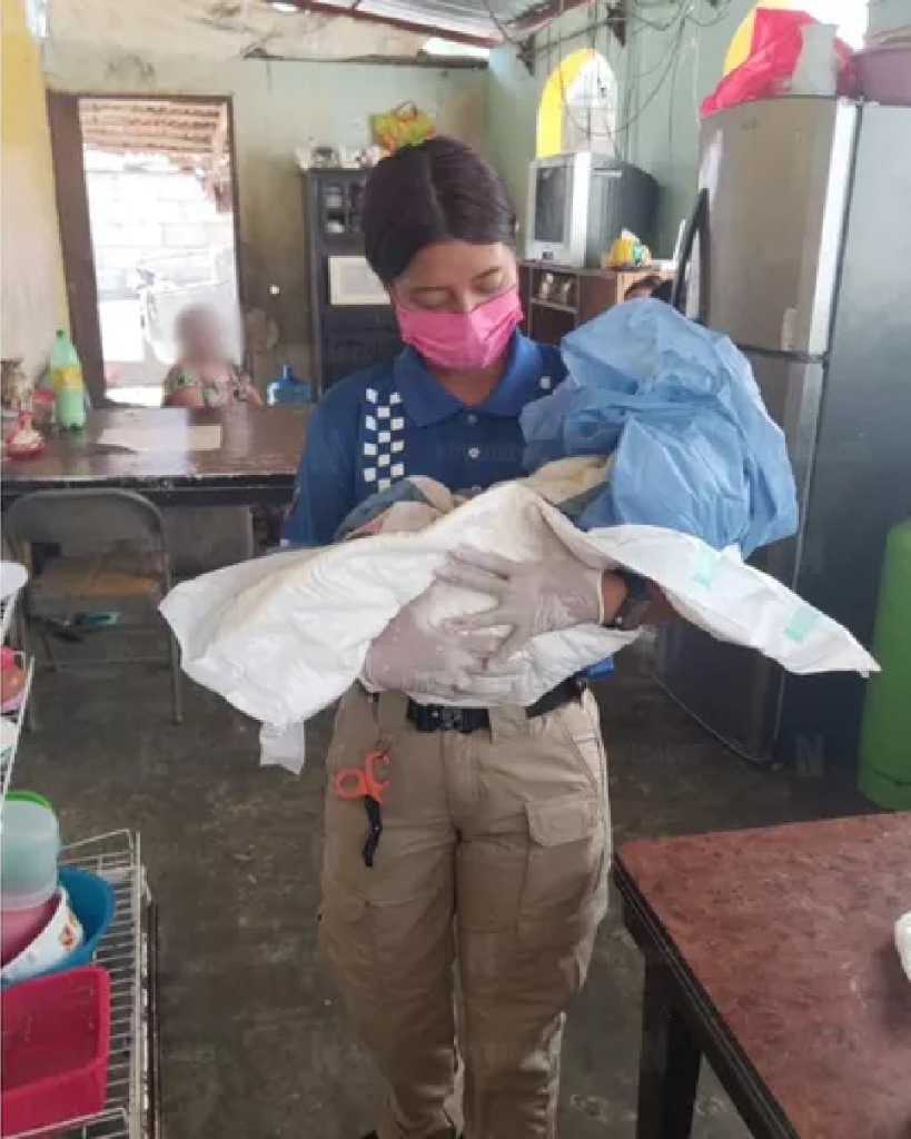 Paramédica sostiene en brazos a bebé recién nacido durante atención prehospitalaria
