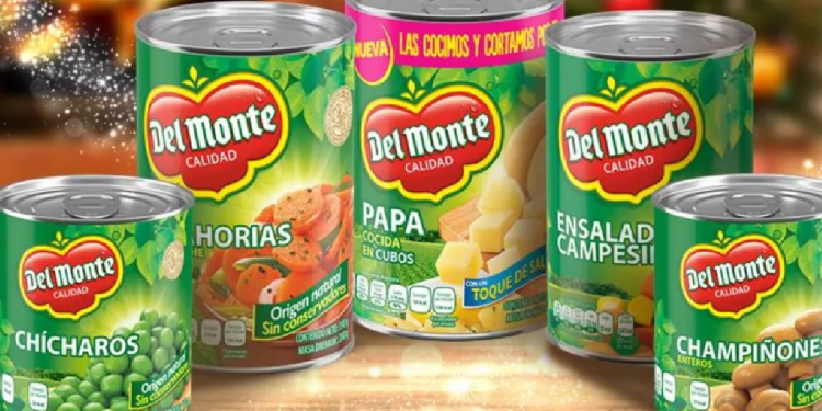 Latas de frutas en almíbar de la marca Del Monte exhibidas en estante.