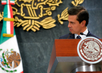 Enrique Peña Nieto con bandera de México de fondo, relacionado con sobornos a Enrique Peña Nieto