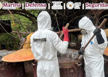 Autoridades mexicanas con trajes de sanidad inspeccionan narco laboratorio en Culiacán