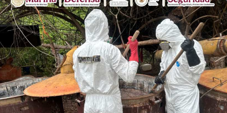 Autoridades mexicanas con trajes de sanidad inspeccionan narco laboratorio en Culiacán