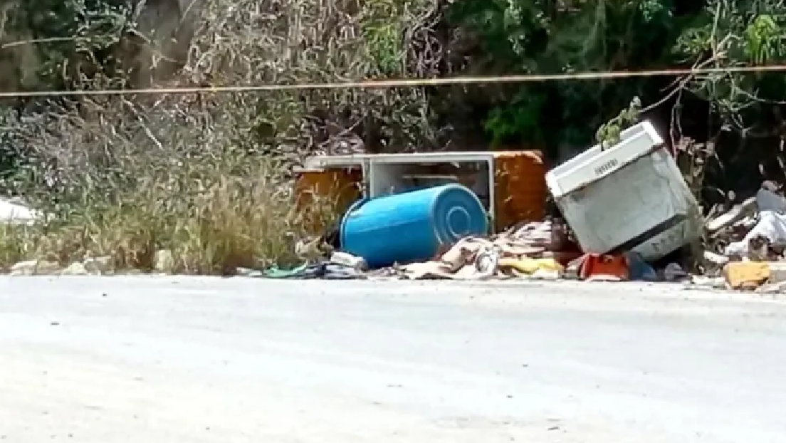 Piernas sobresaliendo de bote de basura en Cancún