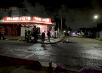 Vista amplia con testigos y tienda "El Origen" en escena de ejecución en Cancún