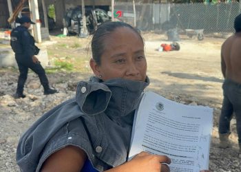 Mujer afectada emocionalmente durante desalojo en la colonia Tren Maya de Tulum