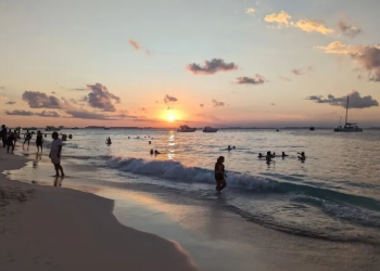 Atardecer en una playa de Cancún con cielo naranja