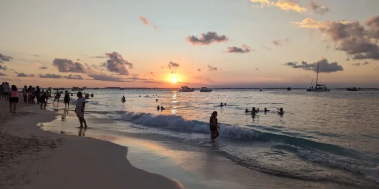 Atardecer en una playa de Cancún con cielo naranja