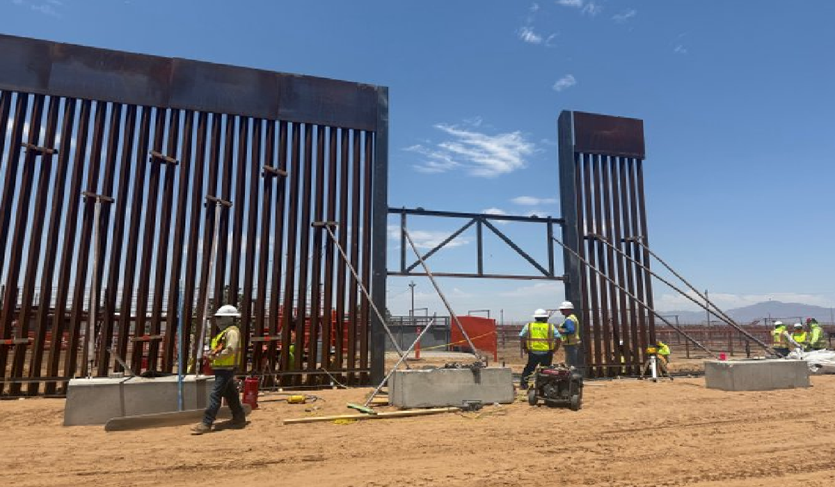 Obreros montan estructuras metálicas del muro fronterizo.