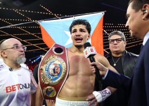 Xander Zayas celebra con el cinturón de campeón superwelter OMB