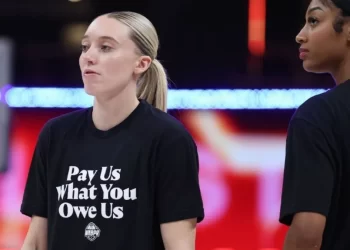 Jugadoras de la WNBA con camiseta que dice "Pay Us What You Owe Us"
