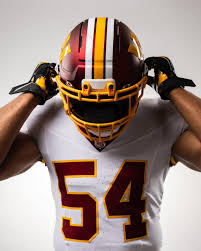 Jugador de los Commanders ajustando su casco alternativo 2025