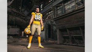 Jugador de Steelers modela uniforme throwback 1933 con casco dorado y jersey amarillo