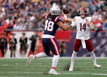 Quarterback de Washington Commanders lanzando pase ante defensivo de New England Patriots en juego de pretemporada NFL 2025.