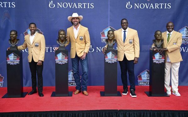 Sterling Sharpe, Antonio Gates, Jared Allen y Eric Allen posan junto a sus bustos en el Salón de la Fama 2025