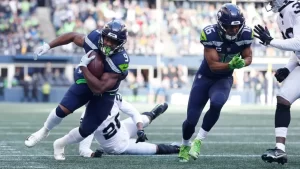 Corredor de Seattle Seahawks avanza con el balón ante defensores de Las Vegas Raiders en la pretemporada NFL 2025.